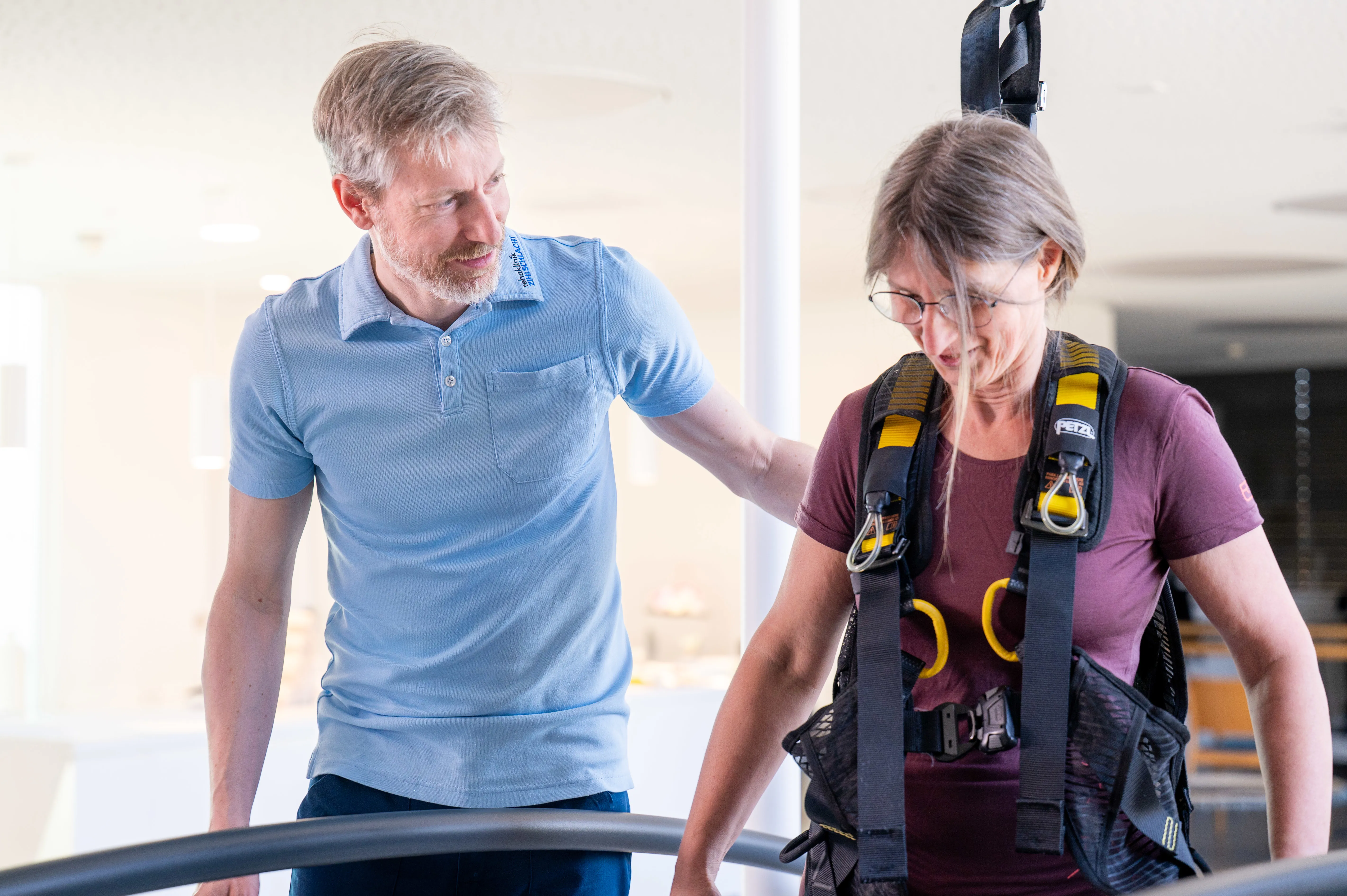 Patientin auf der C-Mill während einer Robotiktherapie, begleitet von einem Therapeuten.