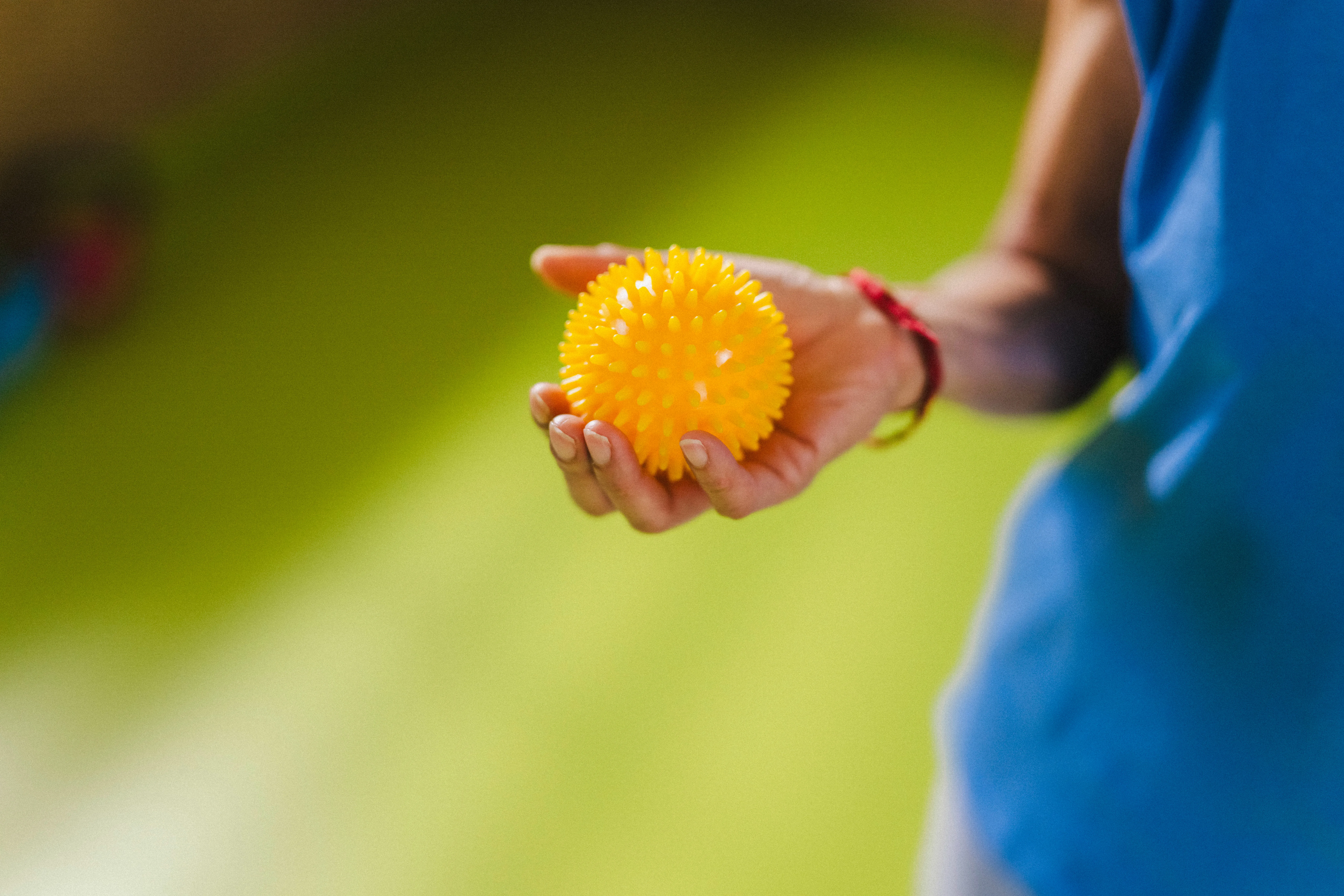 Nahaufnahme auf eine Hand mit gelbem Massageball.