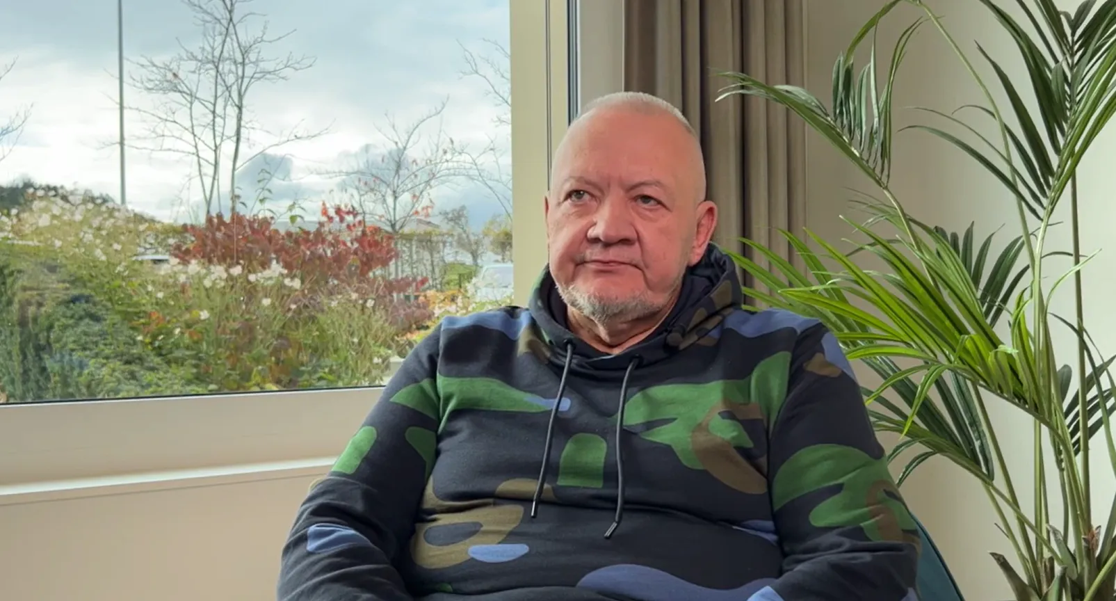 Mann sitzend vor einem Fenster berichtet von seiner Erfahrung als Patient in der Rehaklinik Zihlschlacht.