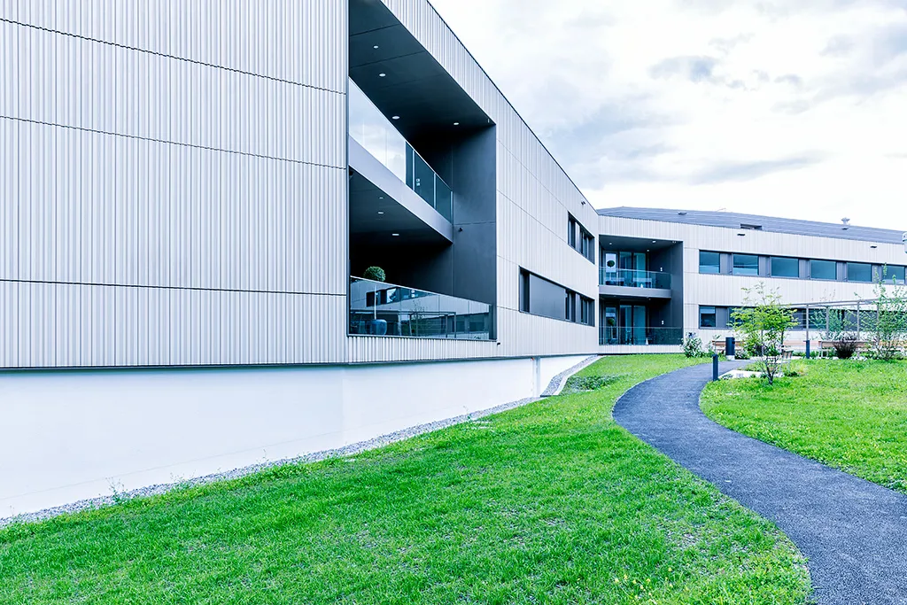 Gebäude der Station Oasis mit Parkgelände.