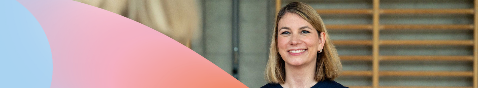 Frau vor Sprossenwand lächelnd.