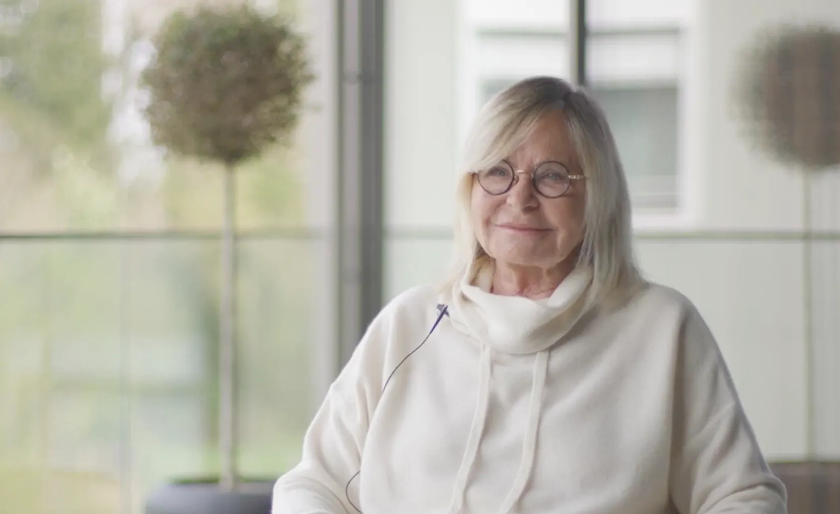 Ältere Frau, die sitzend erzählt wie sie sich in der Rehaklinik Zihlschlacht von Long-COVID erholt hat.