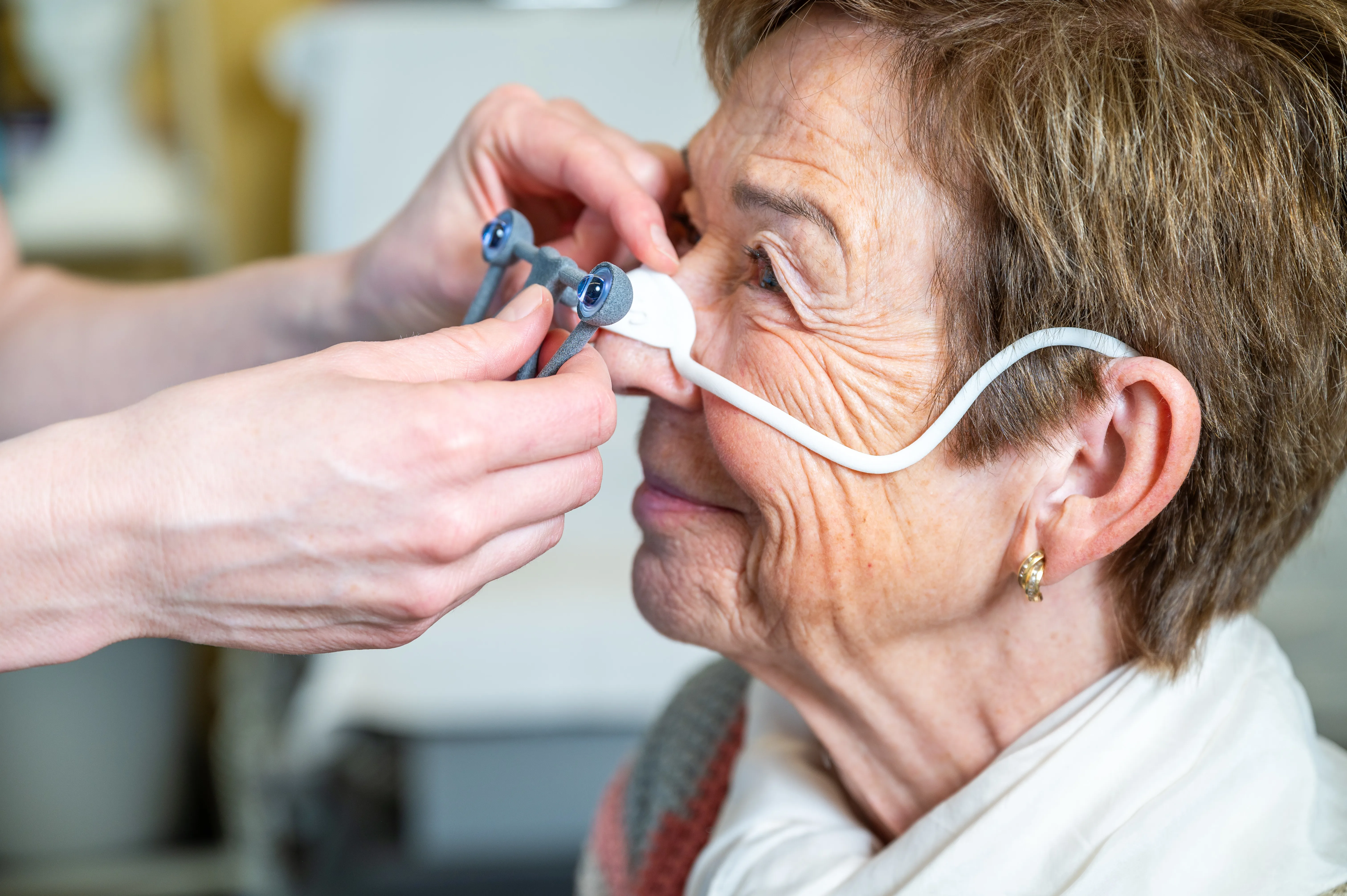 Die Hände einer Therapeutin richten die Patientin für die TPS Therapie ein.