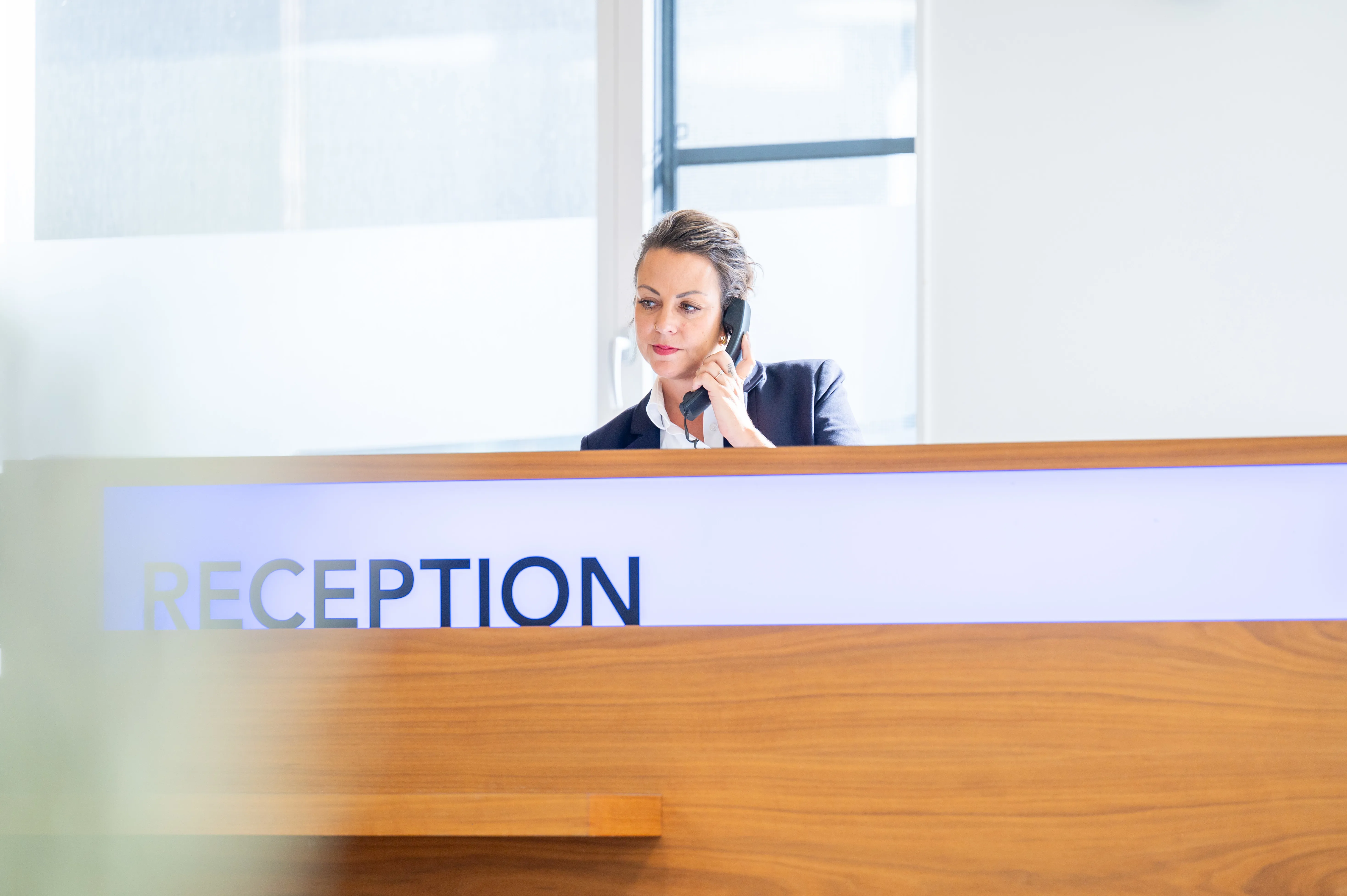 Rezeptionistin einer Rehabilitationsklinik am Telefon.