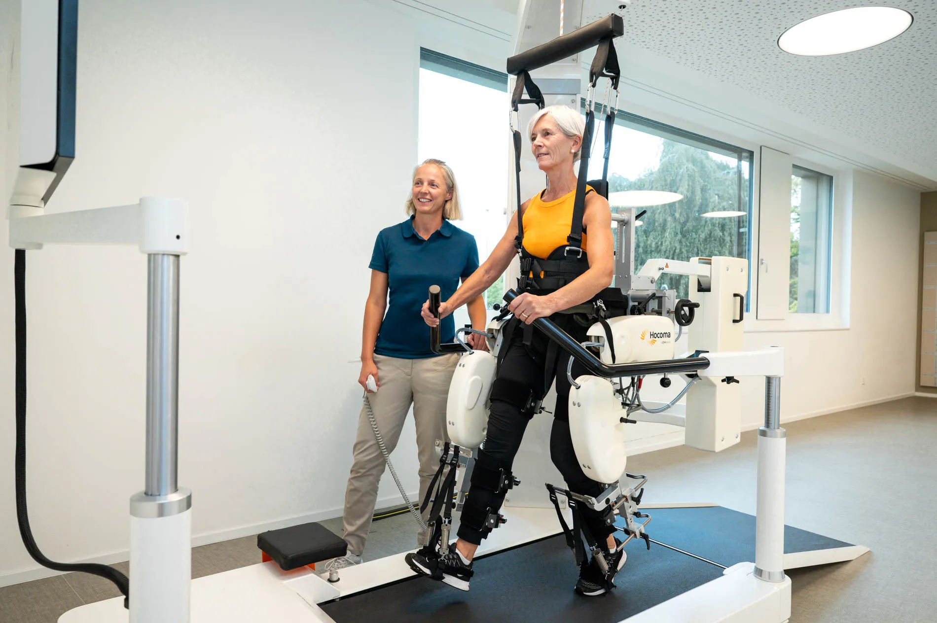 Patientin und Therapeutin während der Therapie mit dem Lokomat® von Hocoma.